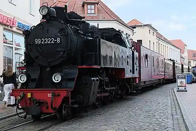 A narrow gauge steam train running through public streets in Bad Doberan