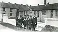 A photograph of Bruree Creamery in County Limerick, Ireland during the 1920s, at which time it was frequently the site of a "Soviet". Seemingly anti Anglo-Irish Treaty graffiti appears on the wall but is obscured by workers posing in front of it[1]