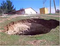 a fresh and short-lived sinkhole. Note that short lived features are not mappable in OSM, so it is not useful to map sinkholes that are going to be filled within days.