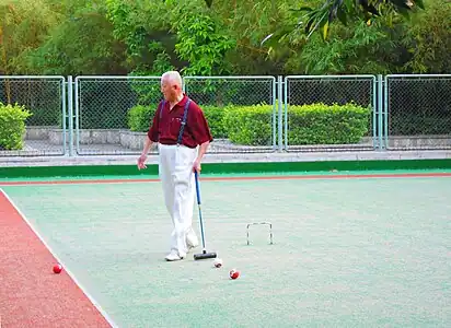 People playing gateball or a variant in Haikou People's Park, Haikou City, Hainan Province, China