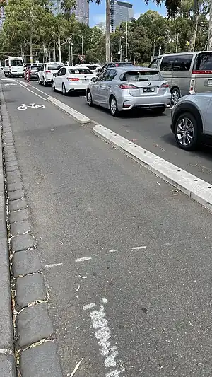 A protected bike lane in Melbourne with road markings and barriers