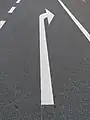 An arrow painted onto the pavement at the start or end of the turn lane