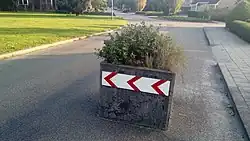 Algunos maceteros colocados en la vía son parte de un traffic_calming=choker o traffic_calming=chicane. Dicha barrier=planter debería combinarse con el valor de traffic_calming=* apropiado y vehicle=yes para indicar que no está bloqueando el paso. ¿O puede etiquetarse como man_made=planter + traffic_calming=choker?