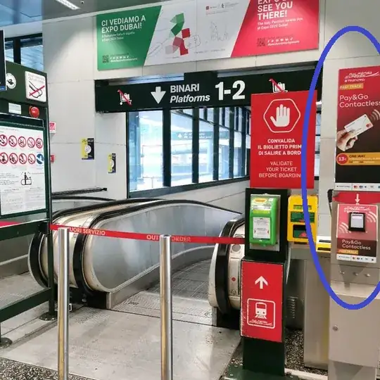 Malpensa Airport Terminal 1 pay and go contactless totem is next to the escalators leading onto the platforms.