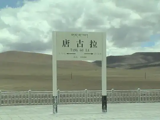 An image of the Tanggula Station platform with hilly landscape behind it.