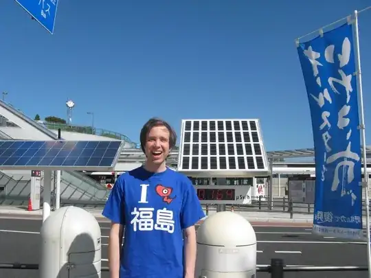Photo of me next to a radiation counter, wearing an "I [akabeko] Fukushima" tshirt. Reading is 0.164 microsieverts per hour