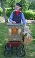 Organ grinder playing a new barrel organ.