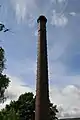 The  120-foot (37&nbsp;m) tall chimney, brick with oversailing caps