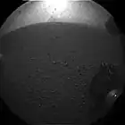 Curiosity's first image after landing – The rover's wheel can be seen (August 6, 2012).