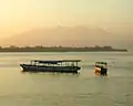 View from Gili Trawangan; in the foreground are island hopper boats anchored off Gili Trawangan, Gili Meno is the next island&nbsp;— Ginung Rinjani is in the distance