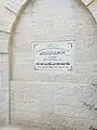 A plaque which was placed on a wall of the mosque, indicating the opening of the modern building to be in the year 2004