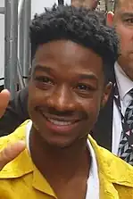 A 24-year-old man with black hair smiles towards the camera.