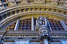 Image shows the entrance to the Victoria and Albert Museum with its stone arches.