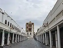 Market street with mosque and tower house, 2020