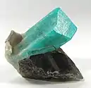 Deep robins-egg blue color amazonite crystal on smoky quartz and albite, from Teller County, Colorado. Size: 3.4&nbsp;cm ×&nbsp;3.3&nbsp;cm ×&nbsp;2.5&nbsp;cm (1.3&nbsp;in ×&nbsp;1.3&nbsp;in ×&nbsp;1.0&nbsp;in).