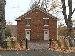 The main façade of the church with two white doors and upper windows