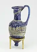 Ancient Egyptian perfume vase in shape of an amphoriskos; 664–630&nbsp;BC; glass: 8 × 4&nbsp;cm (3.1 × 1.5 &nbsp;in); Metropolitan Museum of Art (New York City)