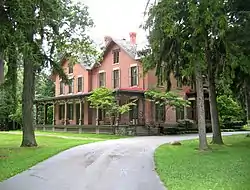 A large brick house surrounded by trees