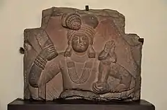 Yaksha holding mudgar and child. Art of Mathura, 100 BCE.